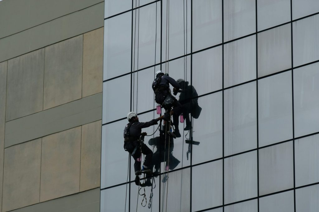 eine Gruppe von Menschen, die aus einem Hochhausfenster hängen